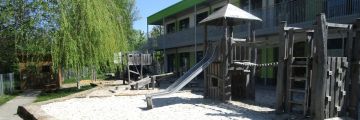 Der Garten mit diversen Spielgeräten und Sandkasten